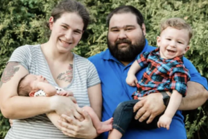 Family with two children outdoors, smiling and enjoying nature.